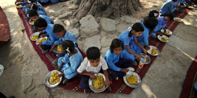 Indian schoolchildren eat a free midday meal, provided on all working days at a government school on the outskirts of Jammu, India, Tuesday, Oct. 9. The United Nations now says its 2009 headline-grabbing announcement that 1 billion people in the world were hungry was off-target and that the number is actually more like 870 million. (AP Photo/Channi Anand)