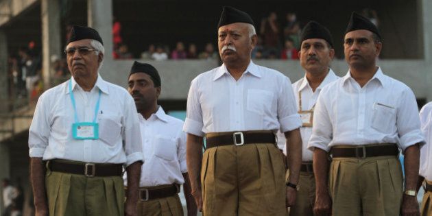 Mohan Bhagwat, chief of the militant Hindu group Rashtriya Swayamsevak Sangh (RSS), center, watches volunteers march during a three-day workers camp on the outskirts of Ahmadabad, India, Saturday, Jan. 3, 2015. The RSS, parent organization of the ruling Bharatiya Janata Party, combines religious education with self-defense exercises. The organization has long been accused of stoking religious hatred against Muslims. (AP Photo/Ajit Solanki)