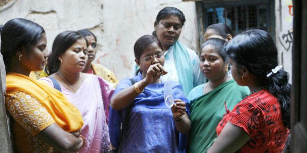 Kolkata, INDIA: TO GO WITH 'HEALTH-AIDS-INDIA-PHARMA' Indian sex workers listen to a volunteer (C) as she demonstrates how to use a female condom, at Soanagachi, Kolkata's largest red-light area, 29 November 2006. India may be leading the way in producing generic HIV-AIDS drugs, but the country is failing to make low-cost treatment available to its own estimated 5.7 million sufferers, activists and experts said ahead of World AIDS Day on 01 December. India has the world's highest HIV-AIDS caseload, and provides anti-retroviral treatment to 55,000 people -- or just seven percent of those who need the drugs, according to the UN's AIDS body. AFP PHOTO/ Deshakalyan CHOWDHURY (Photo credit should read DESHAKALYAN CHOWDHURY/AFP/Getty Images)