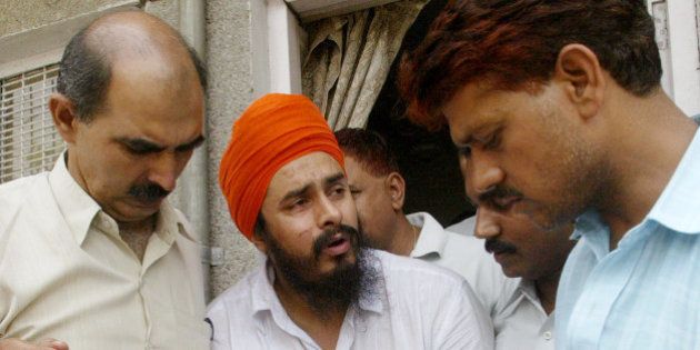 Jagtar Singh Hawara, center, chief of Sikh separatist Babbar Khalsa, reacts in pain as he is shown to the media by police officers of the Crime Branch in New Delhi, India, Wednesday, June 8, 2005. Hawara and two other associates were arrested for their alleged role in the May 22 twin blasts that killed at least one person and wounded 50 at two theaters in New Delhi showing a film condemned by Sikh religious leaders. (AP Photo/Gurinder Osan)