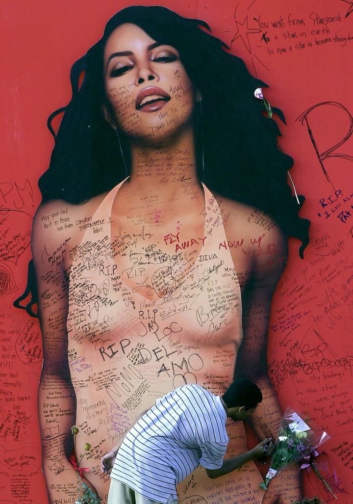 An Aaliyah fan writes a message on a Sunset Boulevard billboard of the singer on Aug. 27, 2001, in West Hollywood, California. 