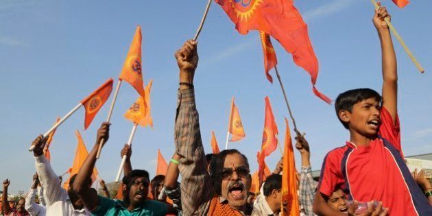 Supporters of right-winged Vishwa Hindu Parishad (VHP) or World Hindu Council raise flags and shout slogans during a rally organized as part of VHP's 50th anniversary celebrations in Bangalore, India, Sunday, Feb. 8, 2015. (AP Photo/Aijaz Rahi)