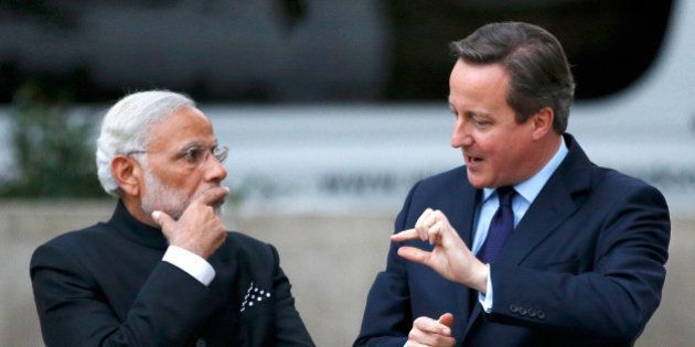 LONDON, UNITED KINGDOM - NOVEMBER 12: Prime Minister David Cameron and India's Prime Minister Narendra Modi chat after paying a visit to the statue of Mahatma Ghandi in Parliament Square during an official three day visit on November 12, 2015 in London, England. In his first trip to Britain as Prime Minister Modi's visit will aim to develop economic ties between the two countries. In a busy schedule he is due to speak at Wembley Stadium, lunch with the Queen at Buckingham Palace, address Parliament and stay overnight at Chequers. (Photo by Peter Nicholls - WPA Pool/Getty Images)