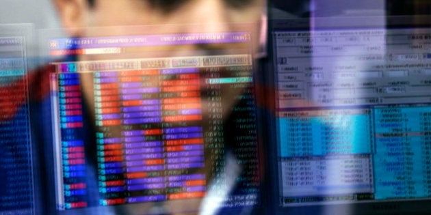 An employee is reflected in a glass panel as he monitors securities on a computer monitor at a brokerage firm in Mumbai, India, on Tuesday, Aug. 25, 2015. Indian stocks advanced in volatile trading a day after the benchmark gauge plunged the most in six years, as banks helped counter declines in software exporters. Photographer: Dhiraj Singh/Bloomberg via Getty Images