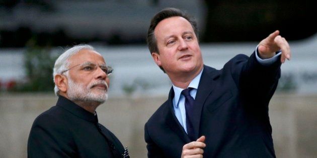 Britain's Prime Minister David Cameron, right, and India's Prime Minister Narendra Modi watch a flypast by the Royal Air Force's Red Arrow display team as they visit the statue of Mahatma Ghandi in Parliament Square, in London, Thursday Nov. 12, 2015. Modi is on a 3 day visit to Britain. (Peter Nicholls, Pool via AP)