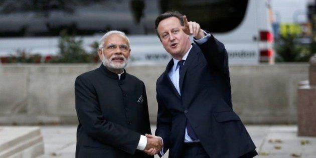 Britain's Prime Minister David Cameron (R) and India's Prime Minister Narendra Modi (L) watch a flypast by the Royal Air Force Red Arrows display team in Parliament square in London on November 12, 2015. India's Prime Minister Narendra Modi will meet Britain's Queen Elizabeth II and address a huge rally at London's Wembley Stadium during a three-day visit to Britain focused on trade and investment starting today. AFP PHOTO / POOL / PETER NICHOLLS (Photo credit should read PETER NICHOLLS/AFP/Getty Images)