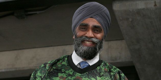 OTTAWA, ON - NOVEMBER 12: The newly elected Canadian Minister of National Defence, The Honourable Harjit Sajjan hams it up while wearing a Sens Camouflage jersey prior to the start of an NHL game between the Ottawa Senators and the Vancouver Canucks on Canadian Forces Appreciation Night during an NHL game at Canadian Tire Centre on November 12, 2015 in Ottawa, Ontario, Canada. (Photo by Jana Chytilova/Freestyle Photography/Getty Images)