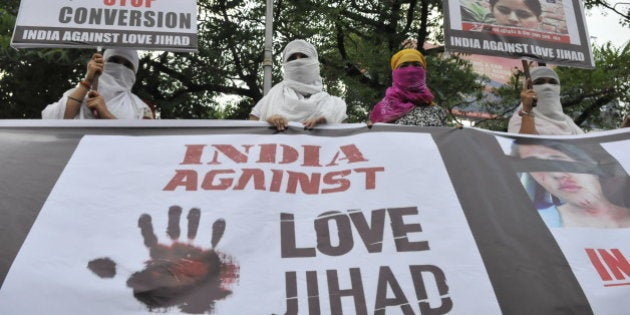 BHOPAL, INDIA - SEPTEMBER 12: Women associated with India Against Love Jihad hold placards and form a human chain to protest against love jihad and conversion to Islam at MP Nagar on September 12, 2014 in Bhopal, India. Hindu rightwing organizations claim that there is an Islamist strategy to convert Hindu women through seduction, marriage and money. (Photo by Mujeeb Faruqui/Hindustan Times via Getty Images)