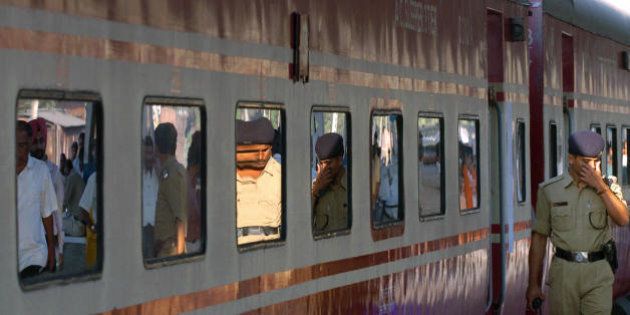 Kolkata, INDIA: Indian policemen are reflected in a train carriage windows as they walk past the high speed air conditioned 'Rajdhani Express' prior to it's departure from a station in Kolkata, 24 February 2006. Indian Railway Minister Laloo Prasad Yadav presented the 2006-07 Railway Budget before Members of the Parliament in New Delhi. The Railway Protection Force (RPF) is being modernised to strengthen passenger security in trains with 'special arrangements' being made for women, Yadav said. AFP PHOTO/Deshakalyan CHOWDHURY (Photo credit should read DESHAKALYAN CHOWDHURY/AFP/Getty Images)