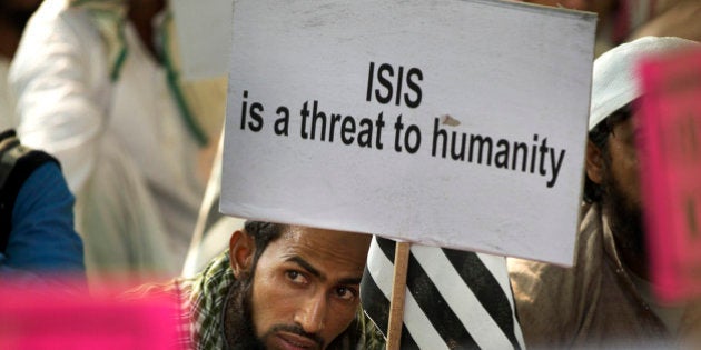 An Indian Muslim man holds a banner during a protest against ISIS, an Islamic State group, and Friday's Paris attacks, in New Delhi, India, Wednesday, Nov. 18, 2015. Multiple attacks across Paris on Friday night have left more than one hundred dead and many more injured. (AP Photo/Manish Swarup)