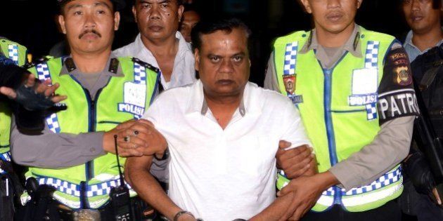 Indonesian police escort Indian national Rajendra Sadashiv Nikalje, 55, known in India as Chhota Rajan, (C) from Bali police headquarters to Ngurah Rai Airport during his deportation from Denpasar on Bali island on November 5, 2015. The Indian fugitive wanted over a series of murders in his country has been arrested in Indonesia after decades on the run, police said. AFP PHOTO / SONNY TUMBELAKA (Photo credit should read SONNY TUMBELAKA/AFP/Getty Images)
