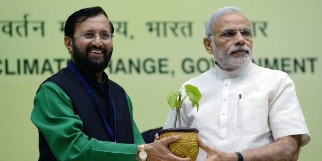 Indian Prime Minister Narendra Modi (R) receives a sapling from Environment Minister Prakash Javadekar during the inauguration of the Enviornment and Forest Minsters conference in New Delhi on April 6, 2015. India's government launched a new air quality index on April 6, 2015, under intense pressure to act after the World Health Organisation declared New Delhi the world's most polluted capital. Environment Minister Prakash Javadekar said the government would publish air quality data for 10 cities, amid growing public concern over the impact of air pollution on the health of India's 1.2 billion people. AFP PHOTO/ PRAKASH SINGH (Photo credit should read PRAKASH SINGH/AFP/Getty Images)