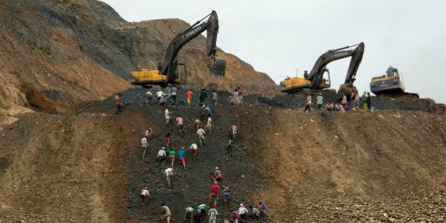 In this June 15, 2015 photo, freelance jade miners collect jade stones in an earth dump of a companies' mining field in Hpakant area, Kachin State, Northern Myanmar. Uncontrolled mining of Myanmarâs famously valuable jade deposits is enriching individuals and companies tied to the countryâs former military rulers while exacting a growing human and environmental toll on impoverished Kachin state. (AP Photo/Hkun Lat)