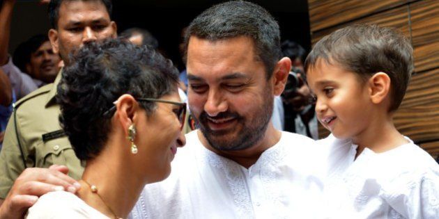 Indian Bollywood actor Aamir Khan, (C), with his wife, director Kiran Rao and son Azad celebrates and wishes his fans Ramzan Eid Mubarak at his residence in Mumbai on July 18, 2015. AFP PHOTO (Photo credit should read STR/AFP/Getty Images)