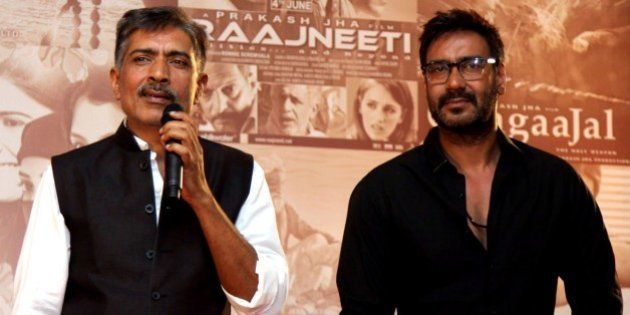 Indian Bollywood actor Ajay Devgn (R) poses for a photograph during a promotional event for new films by Bollywood film producer, director and screenwriter Prakash Jha (L) in Mumbai on October 29, 2014. AFP PHOTO/STR (Photo credit should read STRDEL/AFP/Getty Images)