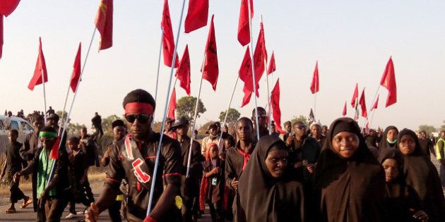 Shiite Muslims march on the highway during a symbolic procession commemorating the 40th anniversary of the Ashura religious ceremony on November 27, 2015 in the village of Dakasoye, northern Nigeria, following a suicide bombing attack. At least 21 people were killed on November 27 when a suicide bomber blew himself up in the crowds at a Shia Muslim procession near the north Nigerian city of Kano, in the latest violence to hit the troubled region. An AFP reporter in Dakasoye said the road was splattered with bloodstains but the followers had continued their march. AFP PHOTO / AMINU ABUBAKAR / AFP / AMINU ABUBAKAR (Photo credit should read AMINU ABUBAKAR/AFP/Getty Images)