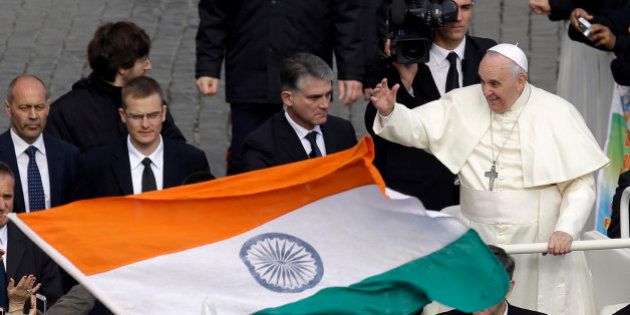 An Indian flag is waved near Pope Francis at the end of the Canonization mass for Eufrasia Eluvathingal, Amato Ronconi, Antonio Farina, Kuriakose Elias Chavara, Nicola Saggio da Longobardi and Ludovico da Casoria, in St. Peter's Square, at the Vatican, Sunday, Nov. 23, 2014. Pope Francis has canonized six new saints, including a priest and a nun from the Indian state of Kerala, in a packed ceremony in St. Peter's Square. The Pope offered prayers Sunday for the saints, four Italians from disparate regions and two Indians from the Syro-Malabar Church, one of 22 Eastern rite churches that operates in full communion with Rome. Some 5,000 faithful traveled from Kerala state for the event, which was also streamed live onto screens set up outside churches in the southern region of India. (AP Photo/Gregorio Borgia)