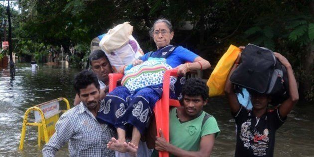 Indian men carry an elderly woman on a flooded street following heavy rain in Chennai on November 16, 2015. Large areas of the southern Indian city of Chennai have been flooded following days of heavy rain. AFP PHOTO (Photo credit should read STR/AFP/Getty Images)