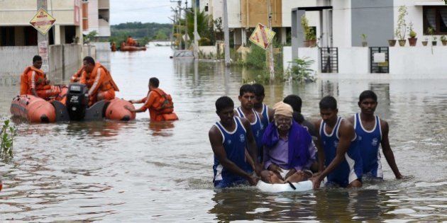 National Disaster Response Force (NDRF) rescue flood affected people during their relief operations in rain-hit areas on the outskirts of Chennai on November 17, 2015. India has deployed the army and air force to rescue flood-hit residents in the southern state of Tamil Nadu, where at least 71 people have died in around a week of torrential rains. AFP PHOTO (Photo credit should read STR/AFP/Getty Images)