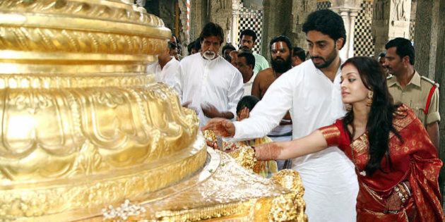 Tirupati, INDIA: Indian actors Abhishek Bachchan (2R) and Aishwarya Rai (R) are watched by Amitabh Bachchan (C) as they touch a golden statue during a visit to The Lord Venkatesh Wara Temple at Tirupati,some 550 kms south of Hyderabad,22 April 2007. Bollywood stars Aishwarya Rai and Abhishek Bachchan began life as 'Mr and Mrs Bachchan' 21 April, after three days of wedding celebrations for Indian cinema's ultimate power couple. AFP PHOTO/NOAH SEELAM (Photo credit should read NOAH SEELAM/AFP/Getty Images)