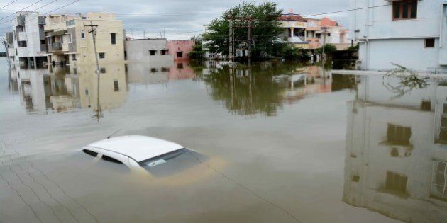 A car is submerged amidst water-logged houses in a rain-hit area of Chennai on November 17, 2015. India has deployed the army and air force to rescue flood-hit residents in the southern state of Tamil Nadu, where at least 71 people have died in around a week of torrential rains. AFP PHOTO (Photo credit should read STR/AFP/Getty Images)