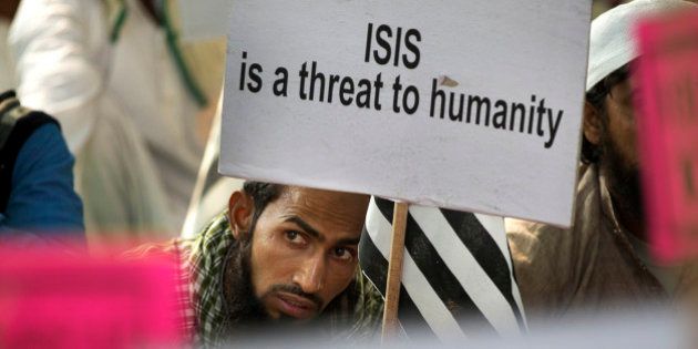 An Indian Muslim man holds a banner during a protest against ISIS, an Islamic State group, and Friday's Paris attacks, in New Delhi, India, Wednesday, Nov. 18, 2015. Multiple attacks across Paris on Friday night have left more than one hundred dead and many more injured. (AP Photo/Manish Swarup)