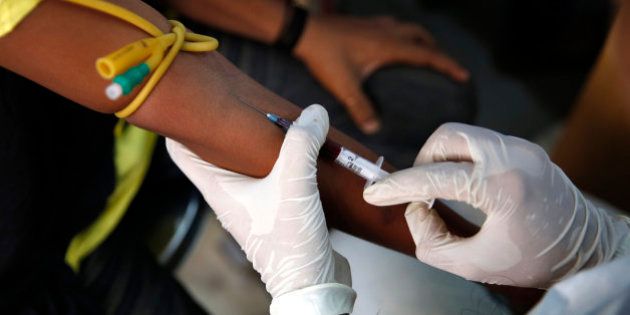 A doctor collects blood sample of a person to be tested for dengue fever at a fever clinic run by a government hospital in New Delhi, India, Thursday, Sept. 17, 2015. India's capital struggles with its worst outbreak of the dengue fever in five years. Outbreaks of the mosquito-borne disease are reported every year after the monsoon season that runs from June to September. (AP Photo/Manish Swarup)