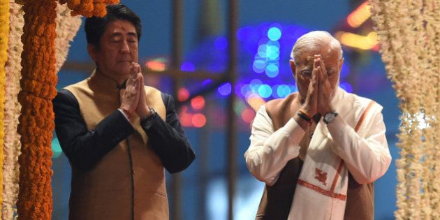 Japan's Prime Minister Shinzo Abe (L) and India's Prime Minister Narendra Modi (R) pray as they attend the evening 'Aarti' ritual on the banks of the River Ganges at Varanasi on December 12, 2015. Japan will build India's first bullet train under a sweeping tally of agreements made following talks in New Delhi on December 12, deepening a partnership Prime Minister Narendra Modi said would 'shape the course of Asia'. Later the two leaders visited the Indian premier's parliamentary constituency of Varanasi, India's holiest city. AFP PHOTO / PRAKASH SINGH / AFP / PRAKASH SINGH (Photo credit should read PRAKASH SINGH/AFP/Getty Images)