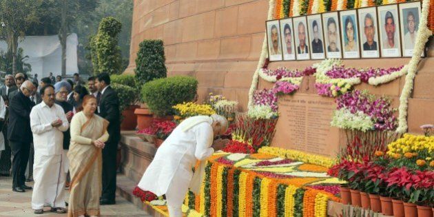 Indian Prime Minister Narendra Modi (R) pays his respects on the 13th anniversary of the 2001 attack on Parliament in New Delhi on December 13, 2014. The 2001 Indian Parliament attack left 14 people - five terrorists, six Delhi Police personnel, two watch and ward staff and a gardener - dead and increased tensions between India and Pakistan. AFP PHOTO (Photo credit should read STR/AFP/Getty Images)