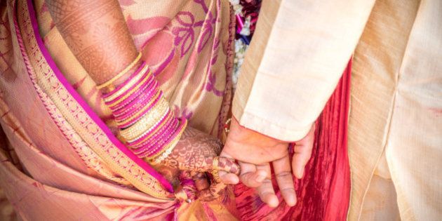 A ritual in Indian Hindu Wedding. Bride and groom holding hands.