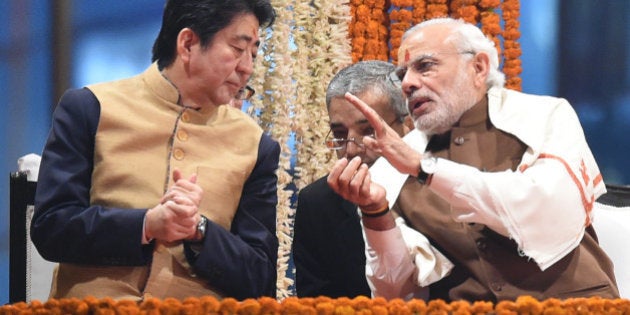 Japan's Prime Minister Shinzo Abe (L) and India's Prime Minister Narendra Modi (R) talk as they watch the evening 'Aarti' ritual on the banks of the River Ganges at Varanasi on December 12, 2015. Japan will build India's first bullet train under a sweeping tally of agreements made following talks in New Delhi on December 12, deepening a partnership Prime Minister Narendra Modi said would 'shape the course of Asia'. Later the two leaders visited the Indian premier's parliamentary constituency of Varanasi, India's holiest city. AFP PHOTO / PRAKASH SINGH / AFP / PRAKASH SINGH (Photo credit should read PRAKASH SINGH/AFP/Getty Images)