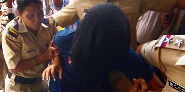 This photo taken on August 29, 2015 shows former Indian media executive Indrani Mukherjea being escorted into a police station through a scrum of media in Mumbai. A former Indian media executive has been arrested on suspicion of murdering her daughter for having an affair with her stepson, Mumbai police said August 27, in a case gripping India. Indrani Mukerjea is accused, along with two others, of strangling Sheena Bora to death in 2012 before dumping her body in a forest in western Maharashtra state and setting it alight. AFP PHOTO (Photo credit should read STR/AFP/Getty Images)