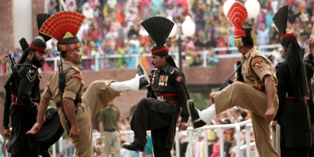 Indian Border Security Force soldiers and Pakistan Rangers soldiers, in black uniform, march during 'Beating the Retreat' or a flag lowering ceremony at the joint border check post of Wagah, India, Wednesday, July 11, 2007. (AP Photo/Aman Sharma)