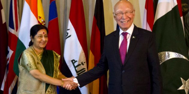 Indian Foreign Minister Sushma Swaraj, left, shakes hand with Pakistani Prime Minister's adviser for Foreign Affairs Sartaj Aziz, right, prior to their meeting in Islamabad, Pakistan, Wednesday, Dec. 9, 2015. Swaraj told a news conference that India and Pakistan had agreed to resume talks, which have been on hold since August when Aziz suspended his visit to India over the issue of Kashmir. (AP Photo/Anjum Naveed)