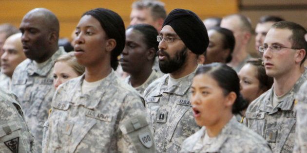 FILE - In this Monday, March 22, 2010 photo, U.S. Army Capt. Tejdeep Singh Rattan, center wearing turban, stands with other graduates as they sing