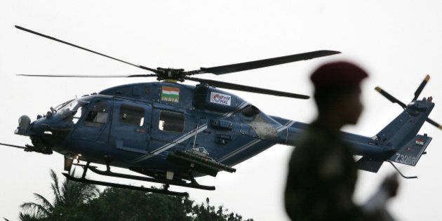 (FILES) In this photograph taken on August 17, 2007, an Indian Army officer stands guard as the weaponised combat Dhruv Helicopter developed by Hindustan Aeronautics Limited (HAL) flies past in Bangalore. India wants to throw off the tag of world's biggest arms importer and produce its own top-class weaponry, but its ambitions hinge on a state-run group renowned for its inefficiencies. HAL, or Hindustan Aeronautics Limited, has a near-monopoly in the country's aerospace industry and its presence was unmissable at this year's India air show, which wrapped up in Bangalore on February 10, 2013. AFP PHOTO/ Dibyangshu SARKAR/ FILES (Photo credit should read DIBYANGSHU SARKAR/AFP/Getty Images)