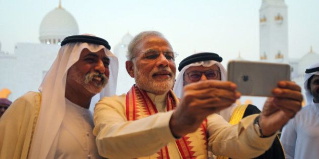 Indian Prime Minister Narendra Modi, middle, takes a selfie next to Sheikh Hamdan bin Mubarak Al Nahyan, UAE Minister of Higher Education and Scientific Research, left, as they tour the Sheikh Zayed Grand Mosque during the first day of his two-day visit to the UAE, in Abu Dhabi, United Arab Emirates, Sunday, Aug. 16, 2015. The UAE is home to over two million Indian expatriates and this is the first visit by an Indian premier in over three decades. (AP Photo/Kamran Jebreili)