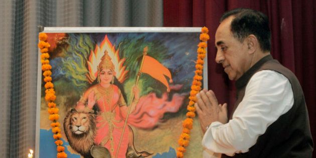 Opposition Janata Party President Subramanian Swamy folds his hand in reverence after a traditional lamp lighting ritual before an illustration representing