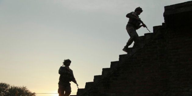 Indian army soldiers climb up the stairs of a residential building outside the Indian air force base in Pathankot, India, Sunday, Jan. 3, 2016. Indian troops were still battling at least two gunmen Sunday evening at the air force base near the country's border with Pakistan, more than 36 hours after the compound came under attack, a top government official said. (AP Photo/Channi Anand)