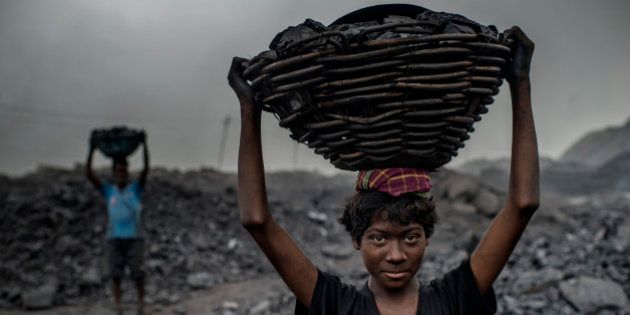 JHARIA, JHARKAND, INDIA - 2014/10/25: 16 year old MD Kahn is a worker at the Jharia coal mine.Jharia in India's eastern Jharkand state is literally in flames. This is due to the open cast coal mining that takes place in the area. For more than 90 years, the Jharian coal mines have been alight with coal mining villages of around seven hundred thousand people settling in. Most of the mining is done with open cast as the price to mine is relatively lower to produce the profits. However, open cast mining does have its disadvantages including the release of toxic chemicals into our atmosphere. Everywhere you look, there will be coal to mine. And so villagers in Jharia often go out with their own shovels to mine whatever coal there is in the ground to support their families after selling the coal at the market center. The open pits of coal on the other hand, often catch fire due to careless cigarette bud tipping or due to lightning strikes in the area and will burn for years to come; spewing toxic and hazardous chemicals into the Earth's atmosphere. About 1.4 billion tonnes of carbon dioxide gets pumped into the atmosphere and could even be considered as the 4th most polluting area of India. Life however, is something that most will fight for, and if destroying the environment means feeding their families; workers will continue to run outside with their shovels and dig up all the coal they can find to survive. (Photo by Jonas Gratzer/LightRocket via Getty Images)