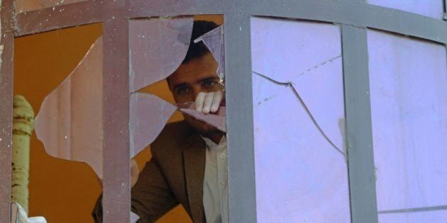 An Afghan man is seen through the shards of a broken window after a blast near the Indian consulate in Jalalabad on January 5, 2016. A small bomb exploded near the Indian consulate in the eastern Afghan city of Jalalabad on January 5, authorities said, after a series of attacks on Indian installations in the region. The blast was some 200 metres from the consulate in Jalalabad, an Indian diplomatic source there told AFP. There were no reported injuries at the scene. AFP PHOTO / Noorullah Shirzada / AFP / Noorullah Shirzada (Photo credit should read NOORULLAH SHIRZADA/AFP/Getty Images)