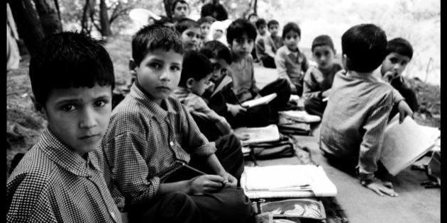 The students at school. This class has students from beginners to about 4th grade. At the end is the teacher. Sitting underneath maple trees bordering the apple orchards, they learn everything from Urdu to counting. Their school building was shelled in December 2006 and has not been repaired yet. Pattan sub-division, Kashmir.
