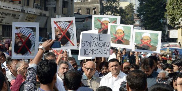Indian activists carry photographs of the chief of Jaish-e-Mohammad, Maulana Masood Azhar (L) and chief of Pakistan's outlawed Islamic hardline Jamaat ud Dawa (JD), Hafiz Mohammad Saeed (R) during a protest against the attack on the air force base in Pathankot, in Mumbai on January 4, 2016. Indian troops backed by helicopters searched an air force base January 4, after a weekend of fierce fighting with suspected Islamic insurgents in which seven soldiers and at least four attackers were killed. AFP PHOTO/ Indranil MUKHERJEE / AFP / INDRANIL MUKHERJEE (Photo credit should read INDRANIL MUKHERJEE/AFP/Getty Images)