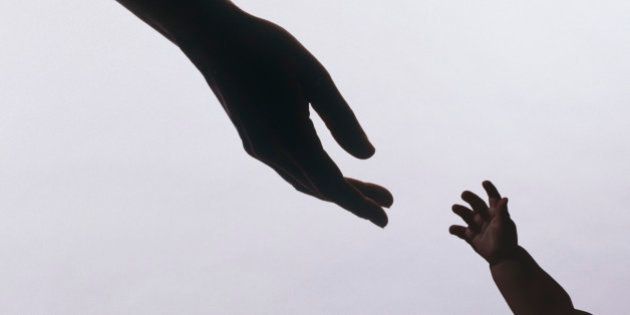 Silhouette of baby's hands reaching for mothers'