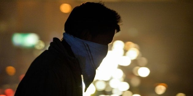 To go with India-environment-pollution,FOCUS by Trudy HarrisIn this photograph taken on December 18, 2015, an Indian commuter covers his face with a handkerchief as he walks on a footbridge near a bus terminus in the Anand Vihar District of New Delhi. Anger and alarm are rapidly rising throughout sprawling New Delhi over the air quality that the World Health Organization (WHO) has ranked the most hazardous on the planet. AFP PHOTO / CHANDAN KHANNA / AFP / Chandan Khanna (Photo credit should read CHANDAN KHANNA/AFP/Getty Images)