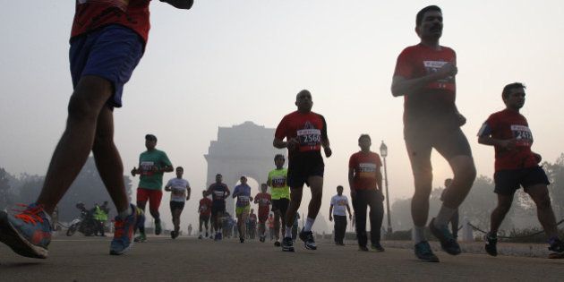 NEW DELHI, INDIA - NOVEMBER 29: Runners take part in Airtel Delhi Half Marathon 2015 at Rajpath in the foggy weather on November 29, 2015 in New Delhi, India. This year Delhi half marathon saw huge participation from countries like Kenya, Ethiopia and Uganda in elite category. Birhanu Legese from Ethiopia and Cynthia Limo of Kenya won the elite men and women categories of Delhi half marathon. Nitendra Singh Rawat and Lalita Babbar bagged the title of the fastest Indian man and woman respectively. (Photo by Raj k Raj/Hindustan Times via Getty Images)