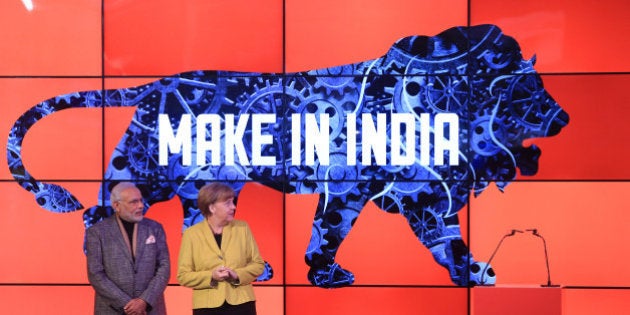 Angela Merkel, Germany's chancellor, right, and Narendra Modi, India's prime minister, stand on stage as a 'Make In India' logo is displayed at the Hanover industrial fair in Hanover, Germany, on Monday, April 13, 2015. Modi said 'huge' opportunities await German industry as he seeks to roll back barriers to foreign investment and speed up growth in Asia's third-biggest economy. Photographer: Krisztian Bocsi/Bloomberg via Getty Images