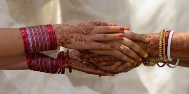 Holding hands during an Indian wedding, India.