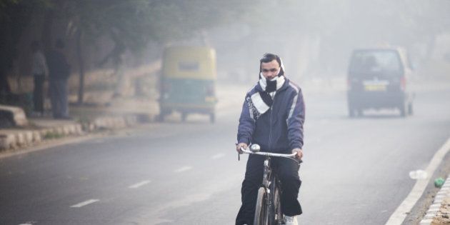 A cyclist travels along a road shrouded in smog in New Delhi, India, on Monday, Jan. 11, 2016. A 2-judge Delhi High Court panel headed by Chief Justice G. Rohini allowed the odd-even traffic restrictions to continue. The measure by Delhi Chief Minister Arvind Kejriwal is the most concerted effort by the government yet to reduce the number of exhaust-belching automobiles in the world's most polluted metropolitan area as discontent among the city's 16.8 million residents grows. Photographer: Prashanth Vishwanathan/Bloomberg via Getty Images