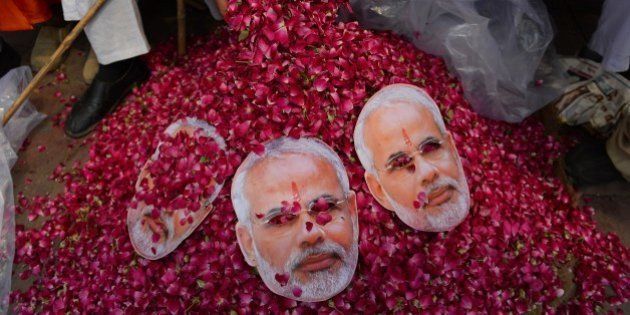 An Indian supporter of the Chief Minister of the western Indian state of Gujarat and Bharatiya Janata Party (BJP) prime-ministerial candidate Narendra Modi collects flowers ahead of his arrival in New Delhi on May 17, 2014. Hundreds of flag-waving supporters mobbed Indian prime minister-elect Narendra Modi as he arrived in New Delhi, smiling and flashing victory signs after his party's crushing poll victory. AFP PHOTO / Chandan KHANNA (Photo credit should read Chandan Khanna/AFP/Getty Images)